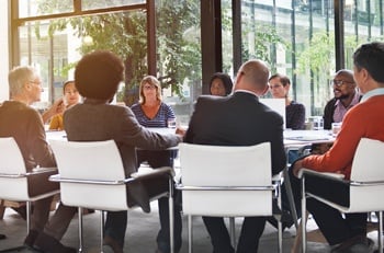 Businesspeople sitting at a large table.